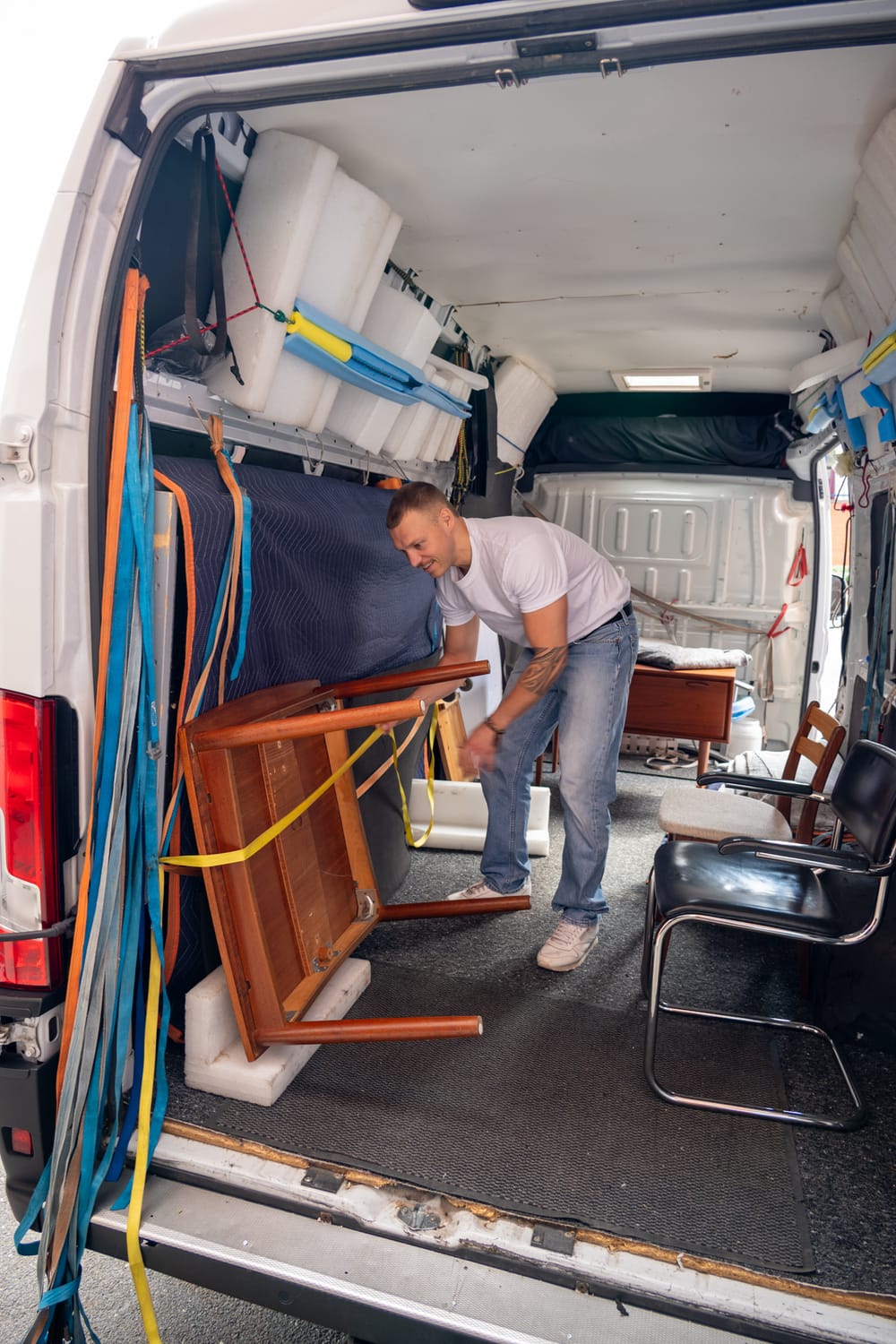 Fahrer übergibt einen Reifen vor einem Wohnhaus